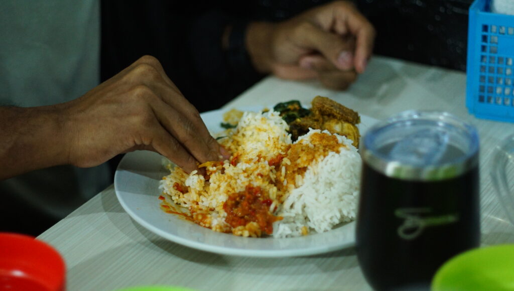 photo of hand ready to eat nasi padang